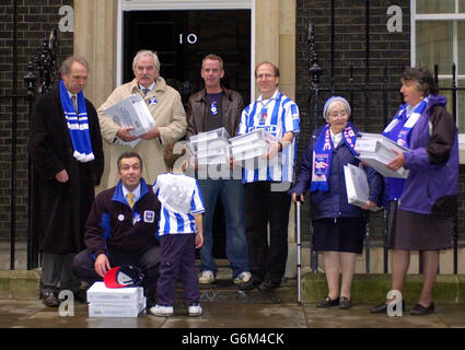 Der TV-Fußballmoderator des Lynam und DJ Norman Cook alias Fatboy Slim kommen mit Mitspielern in der Downing Street an, um 62,000 eine Unterschriftenpetition zu überreichen, in der die Regierung um die Genehmigung eines neuen Stadions für ihren geliebten Brighton und Hove Albion FC gebeten wird. Der Klub der zweiten Division, der derzeit in einem Leichtathletikstadion in Withdean spielt, will in Falmer ein Mehrzweck-Stadion mit 25,000 Sitzplätzen bauen. Von links Lord Bassam von Brighton, des Lynam, Norman Cook, Tim Carder, Mary Emery und Liz Costa. Vorne: Paul Samrah mit dem schüchternen fünfjährigen Sohn Sebastian Samrah. Stockfoto