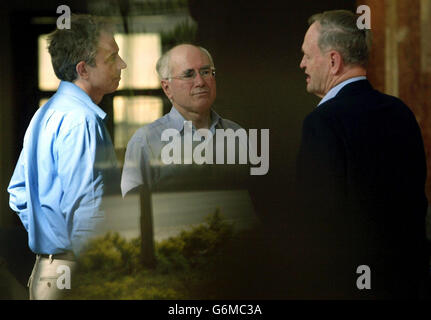 Der britische Premierminister Tony Blair (L) spricht mit dem kanadischen Premierminister Jean Chretien (R) und dem australischen Premierminister John Howard vor dem Beginn eines Treffens der Führer der Commonwealth-Länder in Abuja in Nigeria. Die Anführer sind hinter dem Fenster abgebildet. Stockfoto