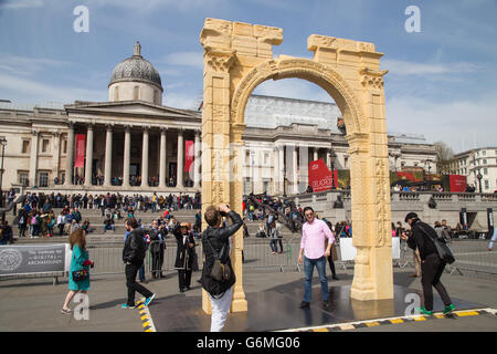 Besucher posiert für Fotos unter Nachbildung von Palmyra Arch of Triumph auf dem Trafalgar Square, London, UK. April 2016. Stockfoto