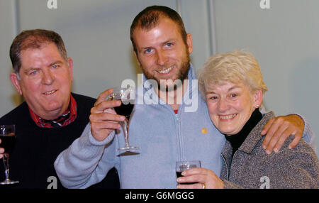 Befreit Geisel Mark Henderson mit seinen Eltern Christopher und Sharelle während einer Pressekonferenz am Flughafen Heathrow, London. Herr Henderson, 32, flog aus Kolumbien, wo er während einer Rucksackreise von Guerillas entführt wurde und 102 Tage lang in abgelegenen Bergwäldern gefangen war. Nach Monaten der Anspannung und Sorge wurde er schließlich Anfang dieser Woche freigelassen. Stockfoto