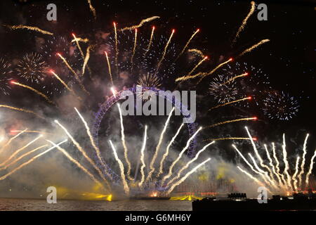 Feuerwerk erleuchten den Himmel über das London Eye in der Londoner Innenstadt während der Feiern des neuen Jahres. Stockfoto