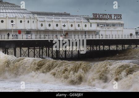 Die Wellen schlagen auf den Strand neben dem Pier in Brighton, East Sussex als Sturmteigel in Großbritannien. Stockfoto