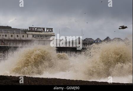 Die Wellen schlagen auf den Strand neben dem Pier in Brighton, East Sussex als Sturmteigel in Großbritannien. Stockfoto