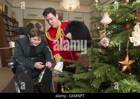 Ethan Browne (links) und Lieutenant Frederick Lloyd George helfen bei der Dekoration eines Weihnachtsbaums im Clarence House in London, bei einem Empfang, der von der Herzogin von Cornwall veranstaltet wird, für Jugendliche und ihre Betreuer aus Helen und Douglas House. Stockfoto