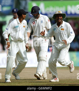 Nasser Hussain (Mitte) verlässt das Feld, nachdem er sein Dickicht an Chuminda Vaas verloren hat, während Tillacaratne Dilshan (links) und Mahela Jayawardena feiern, während England Sri Lanka am letzten Tag des zweiten Tests der drei Testreihen abtritt. Stockfoto