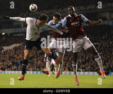 Vlad Chiriches von Tottenham Hotspur geht mit Joey O'Brien von West Ham United und Carlton Cole während des Capital One Cup-Spiels in der White Hart Lane in London als Kopfball. Stockfoto