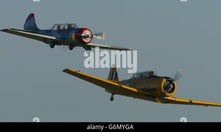 Ein russischer Yak 52 (links) und ein amerikanischer Harvard führen am Mittwoch, dem 17. Dezember 2003, einen niedrigen Flug auf dem Flugplatz HMS Daedalus in Lee auf Solent bei Portsmouth durch, während sich Flugbegeisterte versammeln, um den 100. Jahrestag des ersten motorisierten Fluges der Gebrüder Wright zu begehen. In ihrem revolutionären motorisierten „Flyer“ eroberten die Pionierbrüder am 17. Dezember 1903 als erste die Luft und flogen über eine abgelegene Sandinsel an der Atlantikküste von North Carolina, USA. Stockfoto