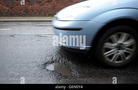 Schlaglöcher in der Peel Street in Oldham. Straßenminister Robert Goodwill testet die neue Smartphone-App "Fill That Hole", mit der mehr Radfahrer Schlagloch-Probleme melden können, während seines Besuchs im Chadderton Way, Oldham. Stockfoto