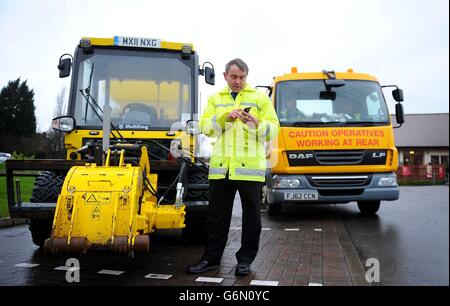 Straßenminister Robert Goodwill testet die neue Smartphone-App "Fill That Hole", mit der mehr Radfahrer Schlagloch-Probleme melden können, während seines Besuchs im Chadderton Way, Oldham. Stockfoto