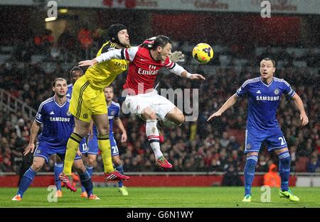 Fußball - Barclays Premier League - Arsenal gegen Chelsea - Emirates Stadium. Chelsea-Torwart Petr Cech schlägt den Ball dem Arsenal-Spieler Mesut Ozil (Mitte) ab Stockfoto