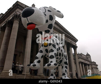 Mitglieder der Öffentlichkeit beobachten, wie der 60 Meter hohe Ballon Dazzle the Dalmation auf dem Londoner Trafalgar Square aufgeblasen wird, um sich auf die Neujahrsparade vorzubereiten. Dazzle, der mehr als 5,000 Kubikfuß Helium benötigt, um ihn zu heben, wird einer von einem halben Dutzend Ballons sein, die am 1. Januar in der Parade erscheinen. Stockfoto