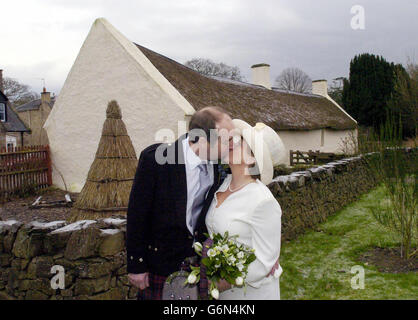 David MacDonald und seine Braut Sheila McNaughton lächeln, nachdem sie in dem Cottage in Alloway, Ayrshire, geheiratet haben, wo der berühmte schottische Dichter Robert Burns geboren wurde. Das Paar, beide Mitte 50 und aus Blackford, Perthshire, sind solche Fans von The Bard, dass sie seine Musik und Rezitale in ihre Hochzeitsfeiern einführten. Stockfoto