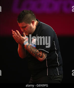 Michael Smith reagiert während seines Spiels gegen Phil Taylor am achten Tag der Ladbrokes World Darts Championship im Alexandra Palace, London. Stockfoto
