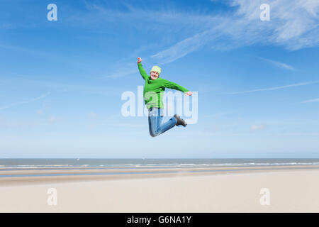 Begeisterte reifer Mann springen am Strand Stockfoto