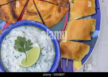 Griechischer Tzatziki Dip und Gebäck auf einem bunten Teller Stockfoto