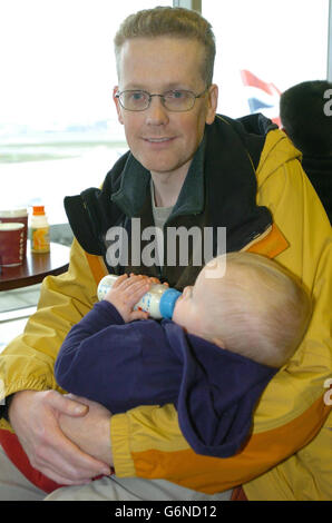 William Mallett und der einjährige Sohn Jack aus Ashford, Middlesex, warten in der Abflughalle im Terminal 4 des Flughafens Heathrow nach der Annullierung ihres Fluges, der BA223 nach Washington. Der Flug wurde aus Sicherheitsgründen am zweiten Tag in Folge annulliert. Am Silvesterabend wurde der gleiche Flug drei Stunden lang auf der Startbahn gehalten, nachdem er am Washington Dulles International Airport landete, um Sicherheitsbeamten zu ermöglichen, das Flugzeug zu besteigen und Passagiere zu befragen. Stockfoto