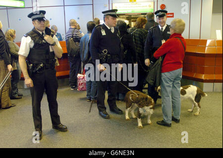 Passagiere an Bord der BA 223 werden von bewaffneter Polizei im Heathrows Terminal 4 beobachtet. Der Flug BA223 von British Airways nach Washington hob schließlich vom Londoner Flughafen Heathrow ab, nachdem die Sicherheitsängste zwei Tage in Folge zu seiner Annullierung geführt hatten. Die 747 Flugzeuge, die 225 Passagiere befördern, verließen mehr als drei Stunden zu spät, inmitten intensiver Sicherheit. Die Polizeipräsenz war hoch mit bewaffneten Polizisten, Sniffer Dogs und Land Rovers, die vor Terminal 4 parkten. Stockfoto