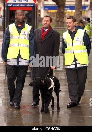 Innenminister David Blunkett geht mit den Straßenwärtern Simeon Whatford (rechts) und Sean Mullins (links) in Shepherd's Bush, West-London, spazieren, als die Regierung ein neues Gesetz einführte, um gegen antisoziales Verhalten vorzugehen. Unter neuen Befugnissen werden Polizisten in der Lage sein, die Häuser von Rissen innerhalb von 48 Stunden zu schließen und sie bis zu sechs Monate lang geschlossen zu halten, und akkreditierte private Sicherheitskräfte werden in der Lage sein, Radfahrer auf dem Bürgersteig zu stoppen. Stockfoto