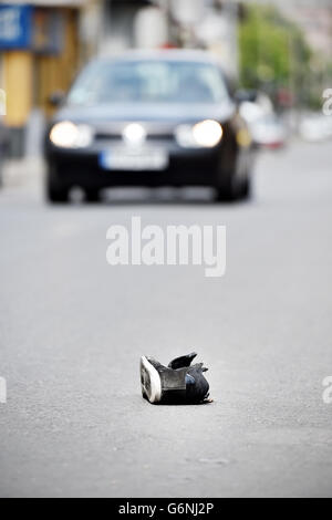 Schuh auf der Straße mit Autos im Hintergrund nach Opfer von Fahrzeug getroffen wurde Stockfoto