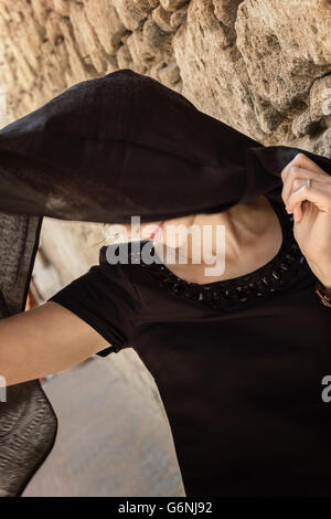 Schöne Frau hinter Kopftuch. Stockfoto