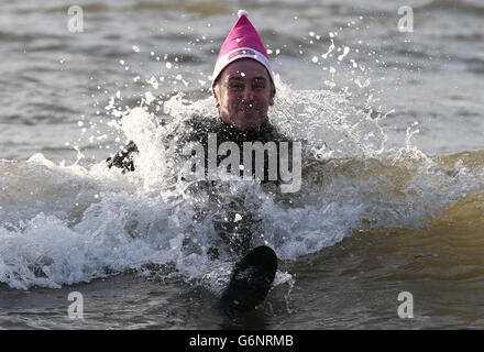 Schwimmen am zweiten Weihnachtsfeiertag. Wohltätigkeitsschwimmer nehmen ein Bad im Meer am Prestwick Beach, um Geld für die Kinderwohlfahrt Clic Sargent zu sammeln. Stockfoto