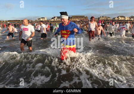 Wohltätigkeitsschwimmer nehmen ein Bad im Meer am Prestwick Beach, um Geld für Kinder wohltätige Clic Sargent sammeln. Stockfoto