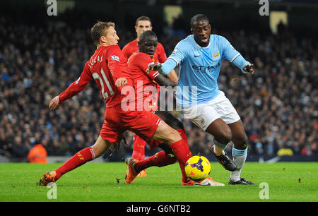 Die Yaya Toure von Manchester City (rechts) kämpft mit Liverpools Mamadou Sakho und Lucas Leiva (links) während des Spiels der Barclays Premier League im Etihad Stadium in Manchester um den Ball. Stockfoto