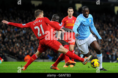 Die Yaya Toure von Manchester City (rechts) kämpft mit Liverpools Mamadou Sakho und Lucas Leiva (links) während des Spiels der Barclays Premier League im Etihad Stadium in Manchester um den Ball. Stockfoto