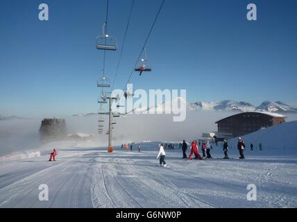 Am frühen Morgen auf der Piste mit niedrigem level Wolke und Skilift-overhead Stockfoto