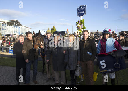 Auch die siegreichen Verbindungen von Cloudy, darunter Jockey Jonathan England (rechts), nach dem Sieg im William Hill Rowland Meyrick Handicap Chase Stockfoto