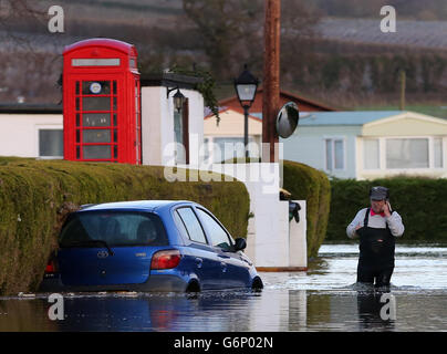 Ein Bewohner spaziert durch den Little Venice Caravan Park in Yalding, Kent, während das Hochwasser nach dem schlechten Wetter wieder an den Ort zurückkehrt. Stockfoto