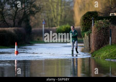 Eine Frau geht durch das Flutwasser im Clifton Hampton in der Nähe von Oxford. Stockfoto