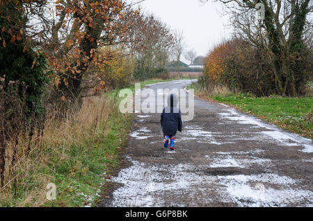 Drei Jahre alter Junge Feldweg zu Fuß im Winter. Leichten Schnee. Stockfoto