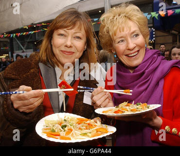 Die Schauspielerin Jenny Agutter (links) und Christine Hamilton, die Frau des ehemaligen Tory-Abgeordneten Neil, stecken in einige der rekordverdächtigen Braten, die Fernsehkochin Nancy Lam am Londoner Leicester Square zubereitet hat. Berühmtheiten wie Christine und Neil Hamilton, Cherie Lunghi und Sian Lloyd wurden erwartet, dass sie sich dem Koch während des sechsstündigen Kochathons anschließen, der abgehalten wurde, um das Bewusstsein für den Great Walk of China 2004 zu schärfen. Stockfoto