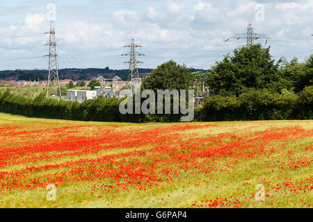 Ein Strom-Sub-Station und Pylonen, Ackerland Feld im Vordergrund. Stockfoto