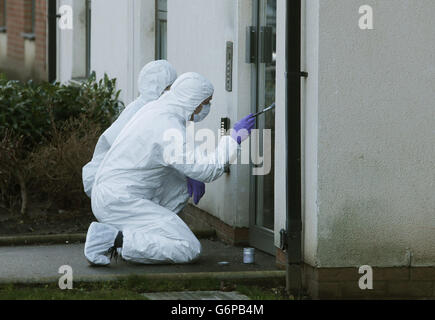 Polizeiforensische Beamte arbeiten an einer Eingangstür zu Wohnblocks in Ferry Gait Crescent, Edinburgh, da der dreijährige Mikaeel Kular aus seinem Haus verschwunden ist. Stockfoto