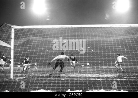 Der schottische Stürmer Peter Lorimer sticht einen Fuß aus und schlägt seinen eigenen Torwart, Bobby Clark, um in der 5. Minute des 100-jährigen Internationalen im Hampden Park Englands erstes Tor zu schießen. Auf der rechten Seite ist England vorne Martin Peters. Stockfoto