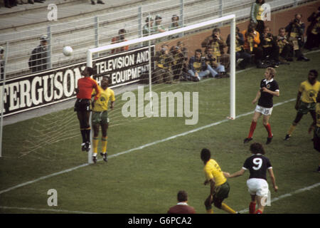 Fußball - FIFA Fußball-Weltmeisterschaft Westdeutschland 1974 - Gruppe 2 - Zaire gegen Schottland - Westfalenstadion, Dortmund. Zaire-Torhüter Kazadi Muamba (l) beobachtet, wie der Ball über die Querlatte geht. Für Schottland (r) ist Denis Law abgebildet. Stockfoto