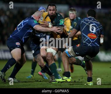 Northampton Saints' Samu Manoa läuft während des Heineken Cups bei Castres' Mihaita Lazar (links) und Mathieu Babillot - Pool One Match in Franklin Gardens, Northampton. Stockfoto