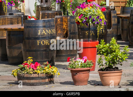 Patio recycelt Whiskey oder Whisky-Fässer verwendet als Tische und Stühle im lokalen Restaurant für ein Essen im Freien. Southport, UK Stockfoto