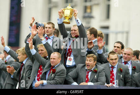 PA-Bibliotheksdatei vom 08/12/2003 von Englands Mike Tindall, der unter seinen WM-siegreichen Teamkollegen die Webb Ellis-Trophäe hält. Am Donnerstag, den 5. Februar 2004, fand in einem Kampfjet die Trophäe der englischen Rugby-Weltmeisterschaft statt, um eine viermonatige Tour durch das Land zu starten. England und Bath Center Mike Tindall werden die Webb Ellis Trophäe in einem Harrier-Jump-Jet begleiten, der von RAF Wittering, Lincolnshire, abheben und am RAF Cosford, Shropshire, zum Beginn der Parade landen wird. Siehe PA Story SPORT Cup. PA Foto: Phil Noble. Stockfoto