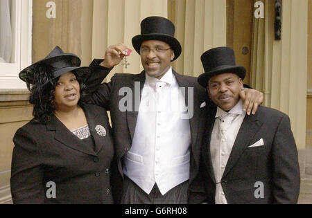 Der ehemalige Boxer Michael Watson, der vor 13 Jahren in einem Kampf mit Chris Eubank Gehirnschäden erlitten hatte, zeigt stolz seinen MBE, während er mit seiner Mutter Joan und seinem Bruder Jeffrey zusammensteht, nachdem er die Ehre von der britischen Königin Elizabeth II. Bei einer Investiturfeier im Buckingham Palace, London, erhalten hatte. Herr Watson, 38, von dem die Ärzte sagten, dass er nie wieder gehen würde, trat ohne Hilfe auf, um die MBE in Anerkennung seiner Arbeit für den Behindertensport zu erhalten. Stockfoto