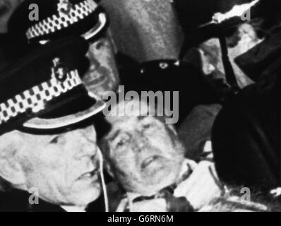 Schottlands legendärer Fußballmanager Jock Stein wurde von der Polizei aus der Touchline getragen, nachdem er zusammengebrochen war und starb, als die letzte Pfeife über die WM-Krawatte seines Teams mit Wales im Ninian Park, Cardiff, hinwegging. Stockfoto