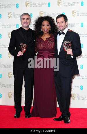 Alfonso Cuaron (links), David Heyman (rechts) mit dem Best British Film Award für "Gravity", zusammen mit Moderator Oprah Winfrey, bei den EE British Academy Film Awards 2014, im Royal Opera House, Bow Street, London. Stockfoto