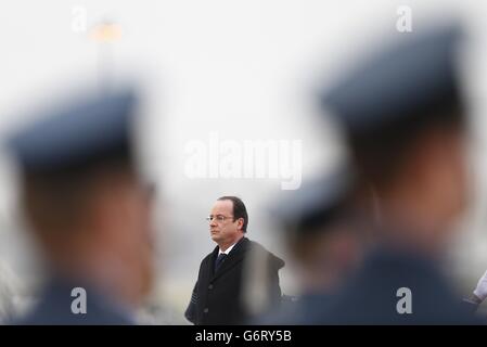 Frankreichs Präsident Francois Hollande hört sich die französische Nationalhymne an, bevor er eine Ehrenwache bei RAF Brize Norton in der Nähe von Oxford in Mittelengland überprüft. Stockfoto