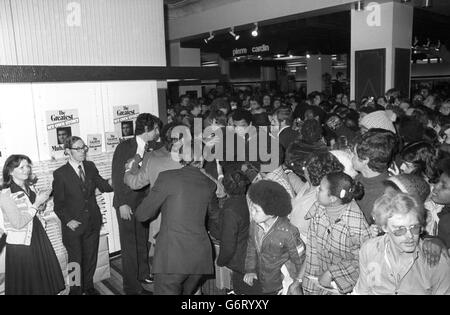 Ein ängstlicher Blick auf das Gesicht des Schwergewicht-Boxweltmeisters Muhammad Ali, der sich durch eine Menschenmenge in der Herrenmode-Abteilung des Selfridges-Geschäfts in der Oxford Street, London, drängt. Stockfoto