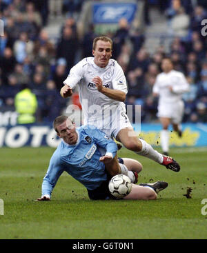 Bolton Wanderers' Henrik Pedersen wird von Manchester City's Richard Dunne (Dunne wurde für das Tackle gebucht) während ihres Barclaycard Premiership Spiels im Reebok Stadium, Bolto, niedergeschlagen. Stockfoto