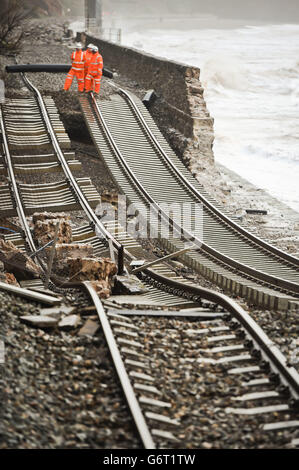 Eine riesige Bahnstrecke ist freigelegt und hängt nach dem Einsturz der Meeresmauer in Dawlish, wo Ebbe und Flut in der Stadt Devonshire verheerende Schäden verursacht haben, die Straßen- und Eisenbahnnetze stören und Eigentum beschädigen. Stockfoto