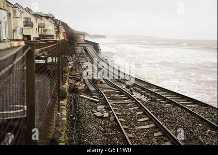 Eine riesige Bahnstrecke ist freigelegt und hängt nach dem Einsturz der Meeresmauer in Dawlish, wo Ebbe und Flut in der Stadt Devonshire verheerende Schäden verursacht haben, die Straßen- und Eisenbahnnetze stören und Eigentum beschädigen. Stockfoto