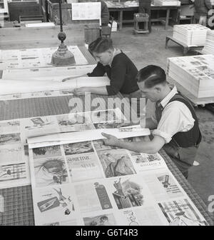 1950er-Jahren, historische, sitzen zwei Mitarbeiter an einem großen Tisch in der Ecke der Fabrik durchläuft den Seiten einer Zeitschrift, die gerade gedruckt worden ist, Fehler und Qualität suchen, Stockfoto